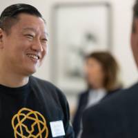 Anthony Chang looking at event guests he is in a conversation with